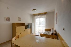 Habitación con mesa y cocina con ventana en Condominio Lavinia, en Bibione