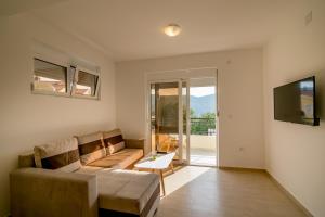 a living room with a couch and a television at SunnyApartments in Herceg-Novi