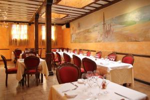 a restaurant with tables and chairs and a painting on the wall at Hotel Fray Tomás in Berlanga de Duero