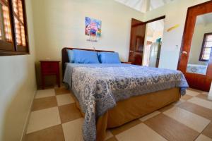 a bedroom with a bed with a blue comforter at Villa at the Beach, Blue Bay Golf & Beach Resort in Blue Bay