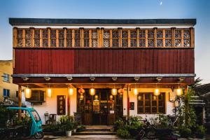 苏州Tongli Begonia Flowers Guesthouse的一座建筑,前有红门和蓝色的汽车