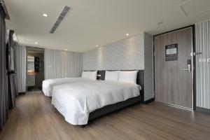 1 dormitorio grande con 1 cama blanca grande y suelo de madera en Golden Pacific Hotel, en Taichung