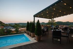 a restaurant with a swimming pool on a deck at Wellness Hotel Villa Magdalena in Krapinske Toplice