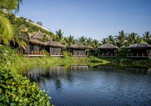 a group of huts with a pond in front at Vinpearl Resort & Spa Nha Trang Bay in Nha Trang