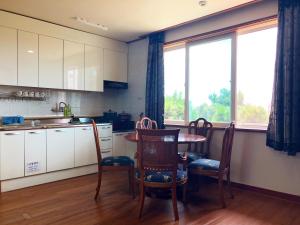 a kitchen with a table and chairs and a window at Haeansung Pension in Seogwipo