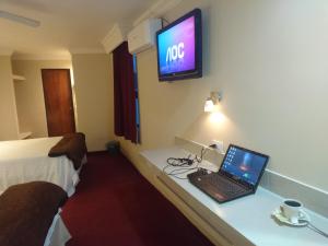 Zimmer mit einem Laptop auf einem Schreibtisch mit einem TV in der Unterkunft Hotel Royal Inn in Monclova