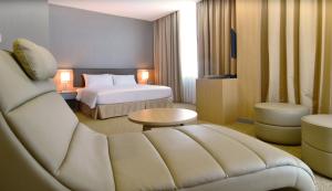 コタキナバルにあるHotel N°5のベッドとソファ付きのホテルルーム
