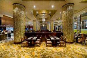 a restaurant with tables and chairs in a lobby at Zhaolin Grand Hotel in Beijing