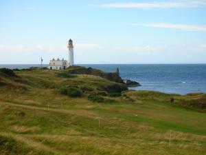 a lighthouse on a hill next to the ocean at Burnside Guest House in Ayr