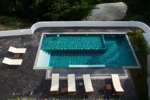 an overhead view of a swimming pool with two chairs at Tropical Sea View Residence in Lamai