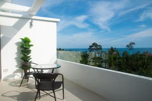 a balcony with two chairs and a table and a view of the ocean at Tropical Sea View Residence in Lamai