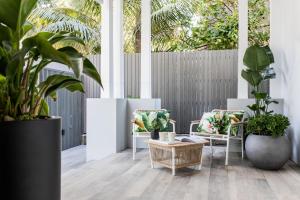 a room with plants and chairs and a fence at The Baxley Bondi in Sydney
