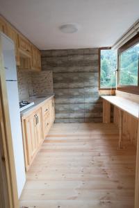 a kitchen with wooden cabinets and a large window at panoramabungalov in Çamlıhemşin