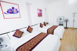 two beds in a room with white walls at K-BOSS Hotel in Bắc Ninh
