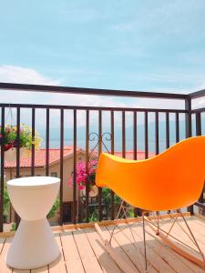 a orange chair sitting on a balcony with a view at Dali lila's house Seaview Guesthouse in Dali