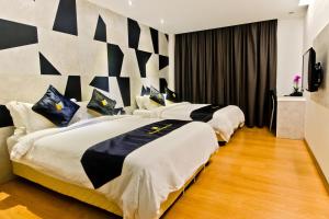 a hotel room with two beds and a television at Mercury Boutique Hotel in Melaka