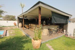 a house with a patio with a table and chairs at Villa Graf in Ongwediva