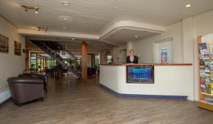 a woman is standing at a counter in a store at Fletcher Hotel-Restaurant Paasberg in Lochem