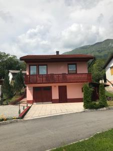 uma casa cor-de-rosa com uma varanda por cima em APARTMA SABOTIČ em Sedula
