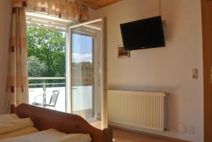 a living room with a couch and a television on the wall at Gästehaus Christa **** in Leibnitz