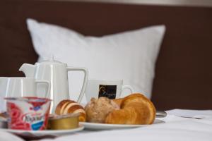 un piatto di pane e croissant su un letto di Hotel Uzwil a Uzwil