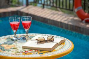 een tafel met twee glazen en een boek en een drankje bij Casa Mare in Praiano