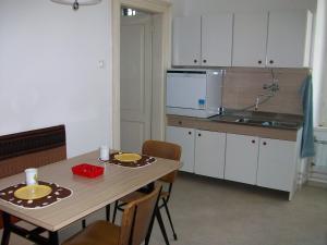 a kitchen with a wooden table and a table and chairs at apartman Cedra in Izola