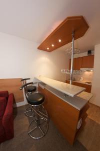 a kitchen with a counter and a bar with stools at Family Apartments Spiežovec in Donovaly