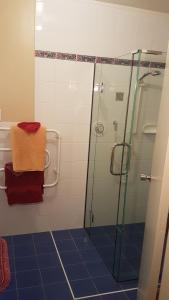 a bathroom with a shower and a towel on a shelf at Carmel Farmstay in Piopio