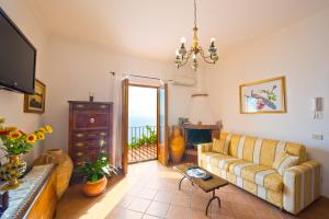 un soggiorno con un divano e una televisione di Villa Tranquillita a Praiano