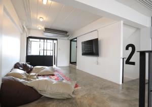 a living room with a couch and a tv at Apartment45 Hostel in Bangkok
