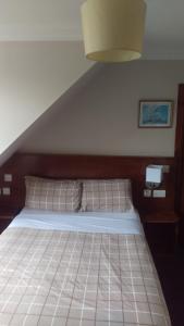 1 dormitorio con 1 cama grande y cabecero de madera en Cambridge House, en Edimburgo