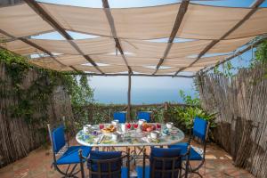 un tavolo e sedie sotto un baldacchino su un patio di Villa Tranquillita a Praiano
