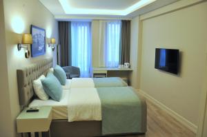 a hotel room with a bed and a television at Centrum Suites İstanbul in Istanbul