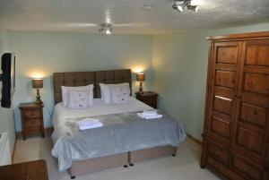 
a bedroom with a bed and a dresser at The Horse & Jockey Inn in Knighton
