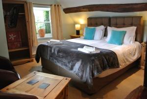 um quarto com uma cama grande e almofadas azuis em The Horse & Jockey Inn em Knighton