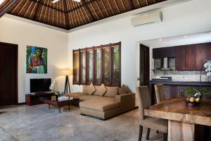 ein Wohnzimmer mit einer Couch und einem Tisch in der Unterkunft Mahagiri Villas Sanur in Sanur