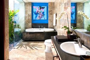 ein Badezimmer mit Badewanne und Waschbecken in der Unterkunft Mahagiri Villas Sanur in Sanur