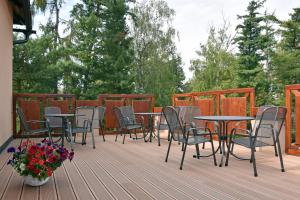 eine Terrasse mit Tischen, Stühlen und Blumen in der Unterkunft Hotel U Kvapilů in Mnichovo Hradiště