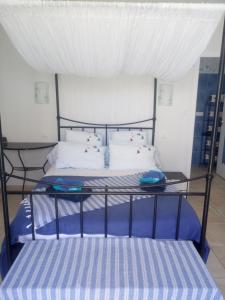 a bed with blue and white sheets and pillows at Les Mouettes in La Cotinière
