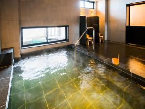 a bath room with a pool of water in it at Super Hotel Fukushima Iwaki in Iwaki