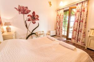 1 dormitorio con 1 cama y una flor en la pared en Villa Terazza-Panorama Apartman en Sümeg