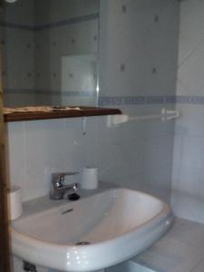 a white sink in a bathroom with a mirror at Aparatamento Rural El Oso 3 in Pola de Somiedo