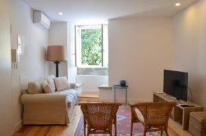 uma sala de estar com um sofá e duas cadeiras em Flor de Lis Residence - Alfama em Lisboa