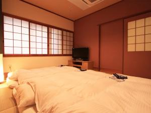Giường trong phòng chung tại Hotel AreaOne Takamatsu