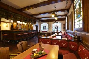 restauracja ze stołem i krzesłami oraz bar w obiekcie Hotel Kaiserpfalz w mieście Paderborn