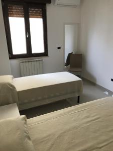 a bedroom with two beds and a chair in it at Condominio Erika in Gallipoli