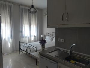 a bedroom with a bed and a kitchen with a sink at Prokymaia Apartment 2 in Áyios Andónios