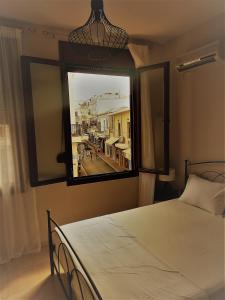 1 dormitorio con cama y ventana grande en Prokymaia Apartment 2, en Áyios Andónios