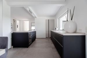 a kitchen with black cabinets and a vase on the counter at Einzigartiges Loft von Loftalive in Lollar
